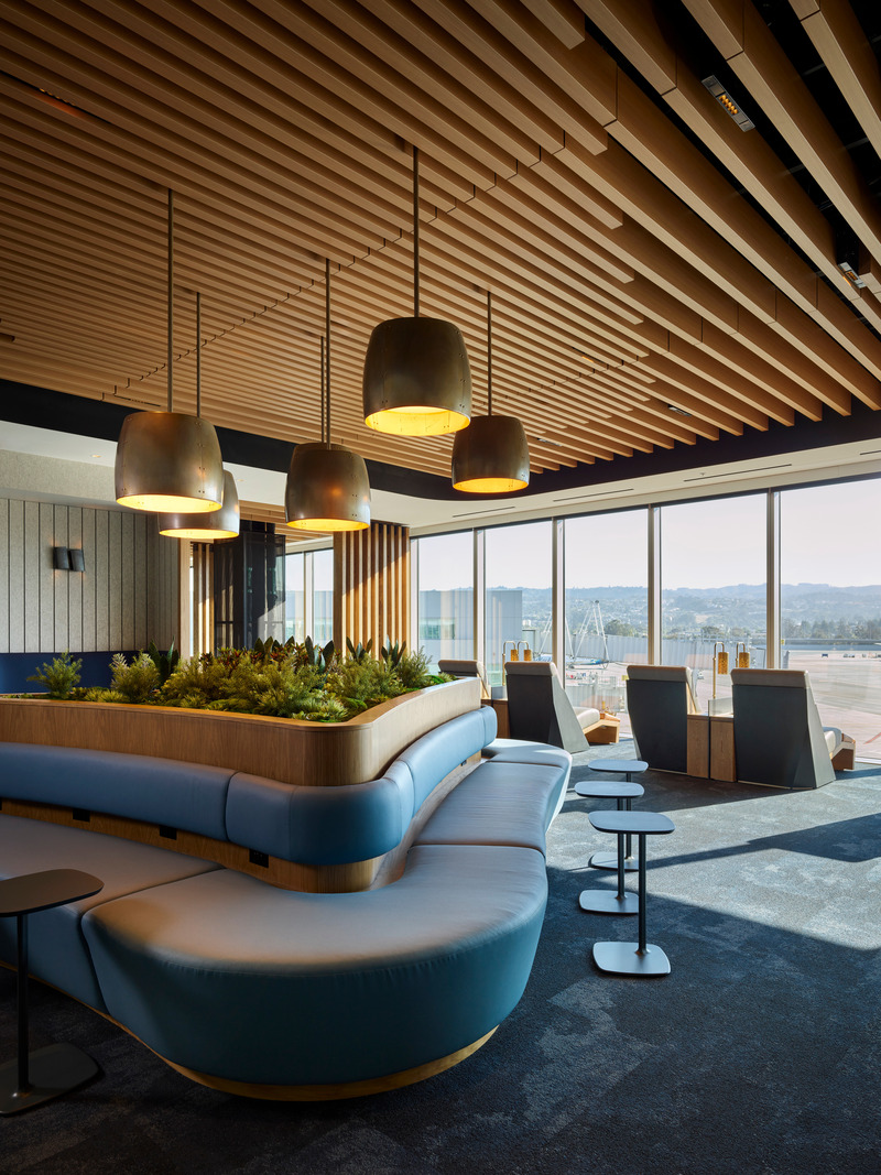 Dossier de presse | 2757-47 - Communiqué de presse | William Duff Architects (WDA) Blends Brand Identity with Bay Area Creativity for Alaska Airlines - William Duff Architects (WDA) - Design d’intérieur commercial -  In the "Take a Breath" area, the seating options include comfortable loungers with views of the runway. - Crédit photo : Matthew Millman