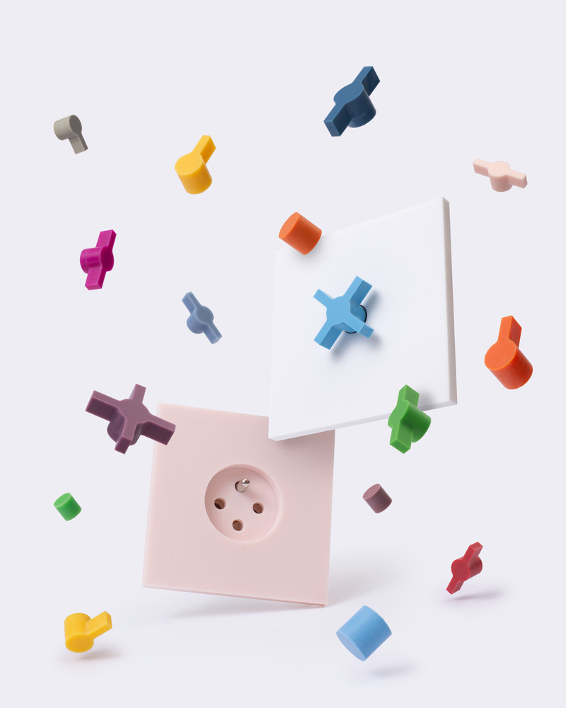 Dossier de presse | 7628-01 - Communiqué de presse | Frame Award 2024 winning switches & sockets - Bright Little Things - Produit -  Confetti Colection - white finishing component 5101 with colorfull buttons Berlin, Paris, London, and Amsterdam - finishing component 5102 (wall oulet) in Krion Pillow Pink  - Crédit photo :  Lyanne Smulders 