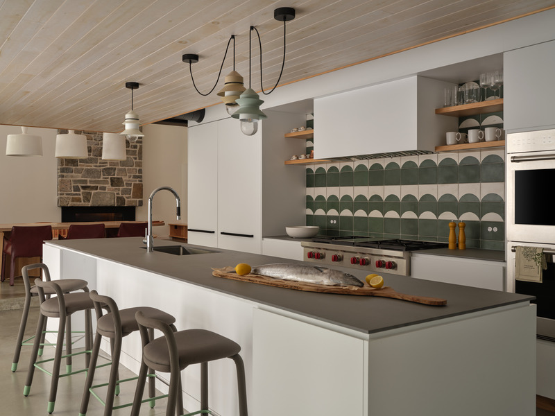 Press kit | 7600-02 - Press release | Shield and Shelter: An Embracing Lakeside Family Retreat that Opens Intimately and Sensitively to its Untamed Surroundings in the Heart of the Muskoka Region - Barbora Vokac Taylor Architect Inc. (BVT A) - Residential Architecture -  View to the kitchen on the lower-ground floor: There exists an architectural dialogue between the built and natural elements that extends through material choices in the interior - from hand-painted cement to whitewashed pine - creating a contemporary retreat that maintains essential connections to its wild context.  - Photo credit: Doublespace