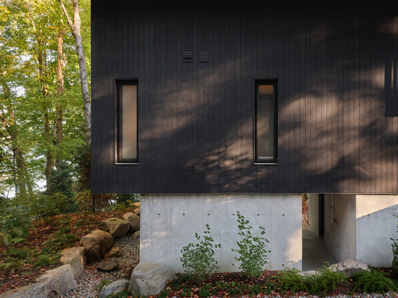 Press kit | 7600-02 - Press release | Shield and Shelter: An Embracing Lakeside Family Retreat that Opens Intimately and Sensitively to its Untamed Surroundings in the Heart of the Muskoka Region - Barbora Vokac Taylor Architect Inc. (BVT A) - Residential Architecture -  The ruggedness of the terrain is offset by the clean detailing of the exteriors. Externally, Shou Sugi Ban cedar walls and sloped black zinc roofs form a distinct silhouette against the landscape.  - Photo credit: Doublespace