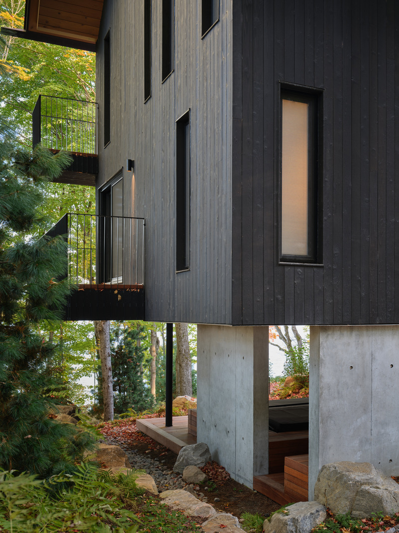 Press kit | 7600-02 - Press release | Shield and Shelter: An Embracing Lakeside Family Retreat that Opens Intimately and Sensitively to its Untamed Surroundings in the Heart of the Muskoka Region - Barbora Vokac Taylor Architect Inc. (BVT A) - Residential Architecture -  View of covered spa area at basement level: Warm wood softens harder materials like concrete and zinc. As the exposed surfaces weather naturally, they create a living chronicle of the family's story across generations.  - Photo credit: Doublespace