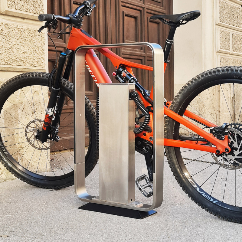 Dossier de presse | 7649-01 - Communiqué de presse | Le Q-RACK : un support pour vélos électriques avec station de recharge intégrée - AttiaDesign - Design urbain - Le ton réfléchissant neutre de l'acier inoxydable, associé à sa finition brossée, assure l'harmonie et une apparence élégante dans son environnement, tout en offrant stabilité et faible entretien. - Crédit photo : AttiaDesign