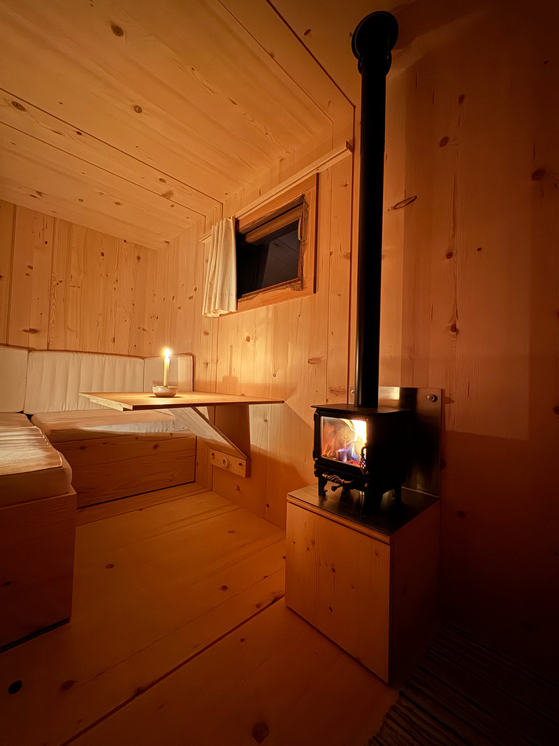 Press kit | 7649-02 - Press release | COCOON Freelancer -  Free of Glue, Chemicals and Plastic - AttiaDesign & Weidlich moon-wood manufactory - Lifestyle -  The Swiss TinyStove creates a cozy and welcoming atmosphere, delivering warmth, comfort, and a true sense of home. Its powerful 3 kW output can raise the COCOON room temperature from 4°C to 20°C in approximately 30 minutes.  - Photo credit: AttiaDesign