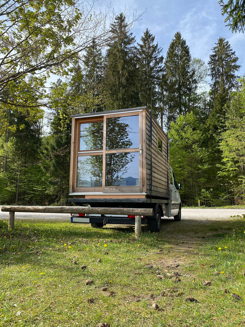 Press kit | 7649-02 - Press release | COCOON Freelancer -  Free of Glue, Chemicals and Plastic - AttiaDesign & Weidlich moon-wood manufactory - Lifestyle -   The COCOON-freelancer is designed to elevate the travel experience to an entirely new level. With its high-value, pure wood construction and a stunning panoramic window, it offers an exclusive feeling of connection to nature and unparalleled comfort.   - Photo credit: AttiaDesign