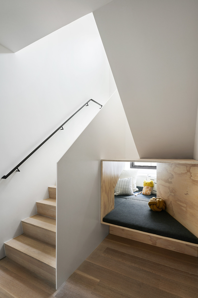 Dossier de presse | 2757-50 - Communiqué de presse | Min Design Elevates the Everyday with Elegant Architecture - Min Design - Architecture résidentielle - Tribeca Penthouse: The under-the-stair space was reimagined as a playful hideout, complete with plywood construction, cushions, pillows, and storage for toys and books, adding a whimsical touch to the home. - Crédit photo :  Brooke Holm 