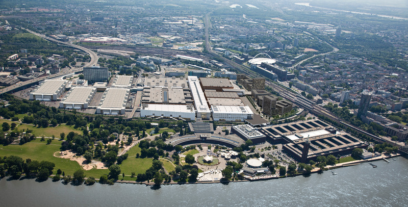 Press kit | 6515-02 - Press release | Confex, Koelnmesse, Cologne Trade Fair - JSWD - Event + Exhibition -  Aerial view from the Rheinpark with Hall 1 (left side), Confex (right side) and planned East-West-Terminal (competition status) <br style="">  - Photo credit: Koelnmesse / JSWD<br>