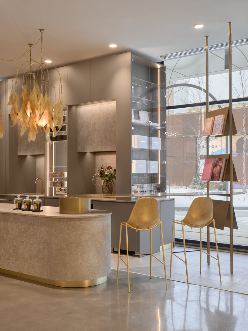 Dossier de presse | 7656-01 - Communiqué de presse | Fendi Casa, Dolce & Gabbana Casa, Versace Home, Bentley Home et Gallotti & Radice rejoignent Maison Territo au Royalmount, marquant un tournant pour le design italien à Montréal - Maison Territo - Design d’intérieur résidentiel -  La perspective côté rue du comptoir Maison Territo révèle des assises dorées élégantes et une bibliothèque suspendue en clin d’œil à l’art et au design. Un lieu à la fois boutique et café, pensé comme une invitation à la découverte. Suspensions sculpturales en laiton par Larose Guyon. - Crédit photo :  Phil Bernard 