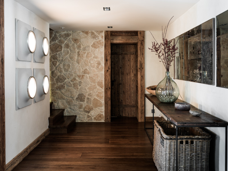 Press kit | 1144-05 - Press release | Rediscovering Luxury Through Circular Design in Verbier - Marianne Tiegen Interiors - Residential Interior Design - Entryway at Chalet 1936 with natural stone walls, wood detailing, and a mix of antique and contemporary furnishings. - Photo credit: J. Wilson