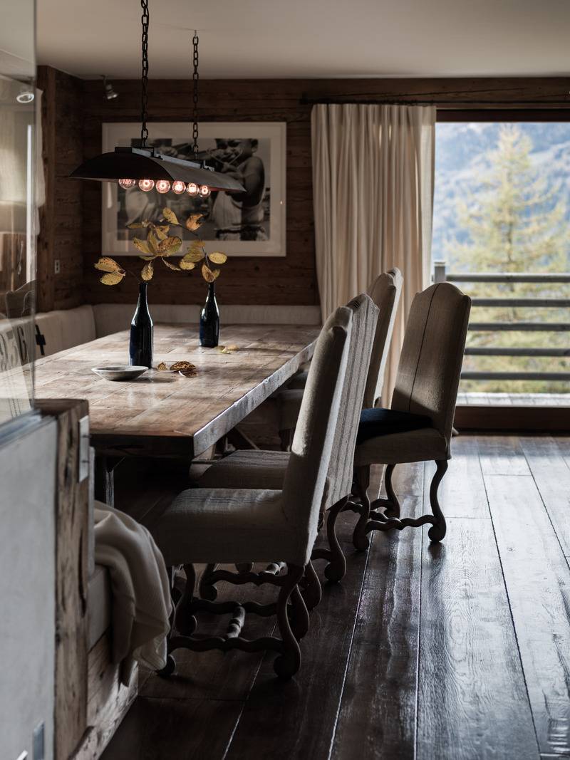Press kit | 1144-05 - Press release | Rediscovering Luxury Through Circular Design in Verbier - Marianne Tiegen Interiors - Residential Interior Design - Dining area with a bespoke oak table and reupholstered 18th-century Os de Mouton chairs. The pendant light was designed by Marianne Tiegen using a reclaimed Parisian zinc gutter. - Photo credit: <p>J. Wilson<br></p> <p></p>