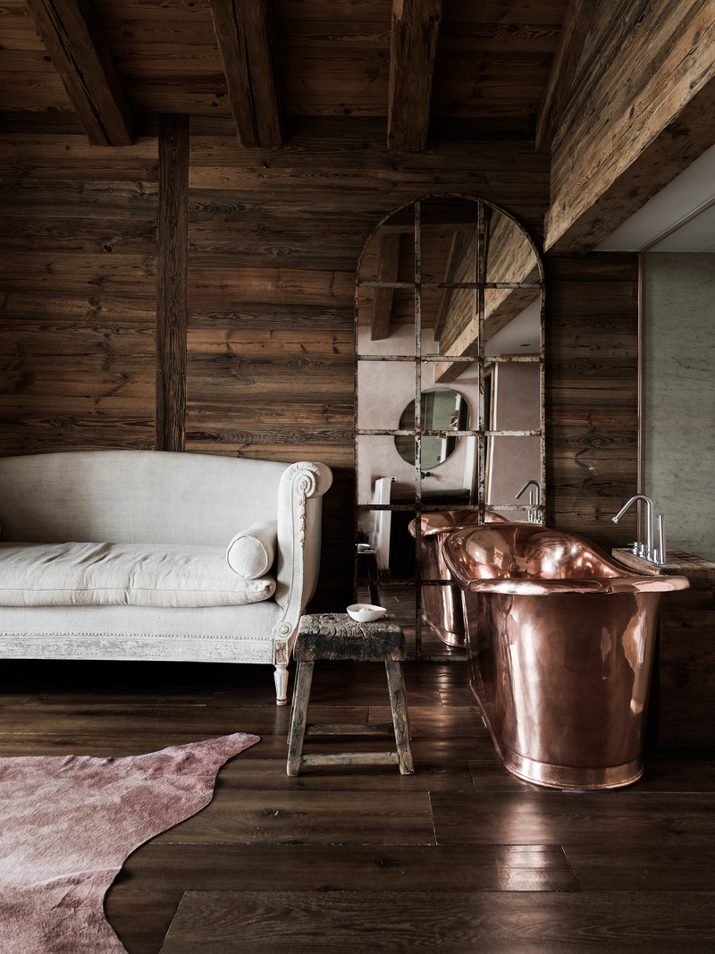 Press kit | 1144-05 - Press release | Rediscovering Luxury Through Circular Design in Verbier - Marianne Tiegen Interiors - Residential Interior Design - <p>Copper bathtub and arched vintage mirror next to an antique linen sofa.</p> <p></p> - Photo credit: J. Wilson