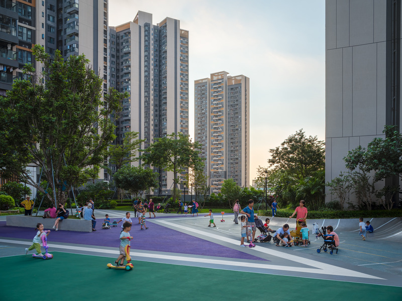 Dossier de presse | 5086-04 - Communiqué de presse | Les Résidences Buji par BAM : couleurs vives - Ballistic Architecture Machine - Architecture de paysage - <p>Enfants et familles profitent du terrain de jeu vert et de la place de rassemblement violette des Résidences Buji, encadrés par un pavement à rayures diagonales sous les tours d’habitation.</p> - Crédit photo : Wu Qingshan