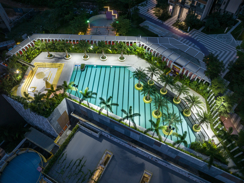 Dossier de presse | 5086-04 - Communiqué de presse | Les Résidences Buji par BAM : couleurs vives - Ballistic Architecture Machine - Architecture de paysage - <p>Vue nocturne aérienne de la terrasse-piscine des Résidences Buji, où la piscine de nage turquoise rayée est bordée de nids d’assise circulaires jaunes et de palmiers Washingtonia, et jouxte une piscine pour enfants agrémentée d’éléments ludiques en mosaïque jaune et noire.</p> - Crédit photo : Wu Qingshan