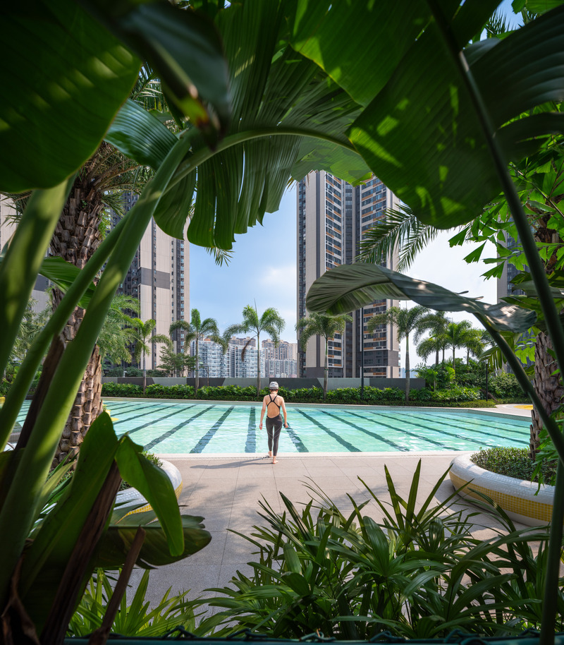 Dossier de presse | 5086-04 - Communiqué de presse | Les Résidences Buji par BAM : couleurs vives - Ballistic Architecture Machine - Architecture de paysage - <p>Encadré par la végétation tropicale, un nageur s’avance vers la piscine de nage turquoise rayée, bordée de nids d’assise circulaires jaunes et de palmiers Washingtonia, tandis qu’au loin se profilent les tours d’habitation.</p> - Crédit photo : Wu Qingshan