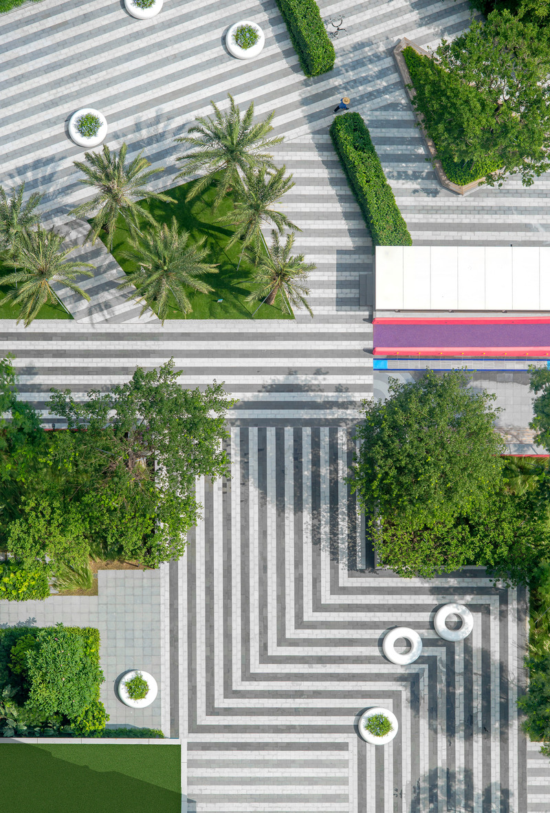 Dossier de presse | 5086-04 - Communiqué de presse | Les Résidences Buji par BAM : couleurs vives - Ballistic Architecture Machine - Architecture de paysage -  <p>Vue aérienne détaillée de la place des Résidences Buji, où les zones paysagères fonctionnelles sont définies par des motifs à rayures classiques, dans une composition dynamique qui équilibre fort contraste, végétation luxuriante et couleurs vives.</p> - Crédit photo : Amey Kandalgaonkar