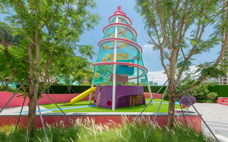 Dossier de presse | 5086-04 - Communiqué de presse | Les Résidences Buji par BAM : couleurs vives - Ballistic Architecture Machine - Architecture de paysage -  <p>Aire de jeux Playscraper aux Résidences Buji, avec une base violette et des anneaux roses entourant une structure en treillis bleu ponctuée de modules d’escalade jaunes et d’un toboggan, installée au cœur d’une végétation luxuriante sous les tours.</p> - Crédit photo : Amey Kandalgaonkar