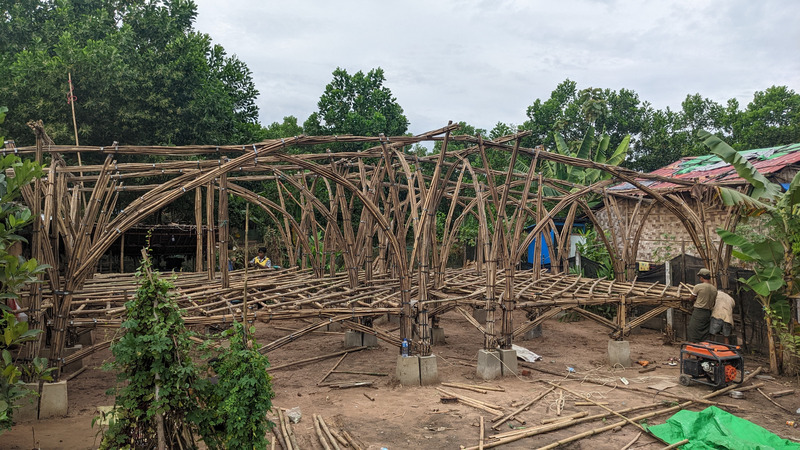 Press kit | 7035-02 - Press release | Bamboo Housing Resists 7.7 Earthquake in Conflict-Torn Myanmar, Built for Displaced Families - Blue Temple - Institutional Architecture - Exterior view of bamboo modular housing under construction, showing bundled frame assembly. - Photo credit: Raphaël Ascoli