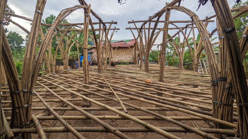 Press kit | 7035-02 - Press release | Bamboo Housing Resists 7.7 Earthquake in Conflict-Torn Myanmar, Built for Displaced Families - Blue Temple - Institutional Architecture - Interior perspective of bamboo modular housing under construction, showing bundled frame assembly. - Photo credit: Raphaël Ascoli