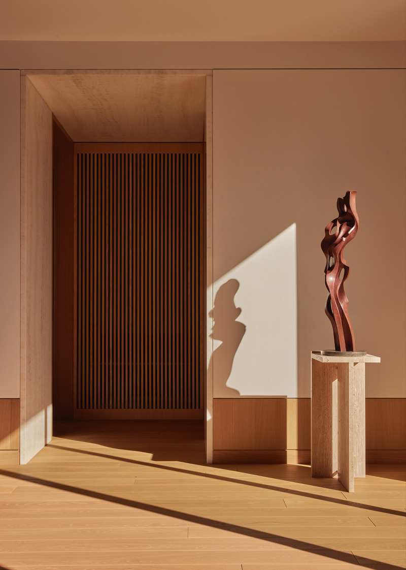 Press kit | 6087-07 - Press release | Study in Serenity: A Beachside Haven of Precision and Craftsmanship - Daniel Joseph Chenin - Residential Interior Design - Afternoon light casts sculptural shadows across the entry hall, where vertical oak slats and a travertine pedestal create a dialogue of rhythm, restraint, and refinement. - Photo credit: Tim Hirschmann