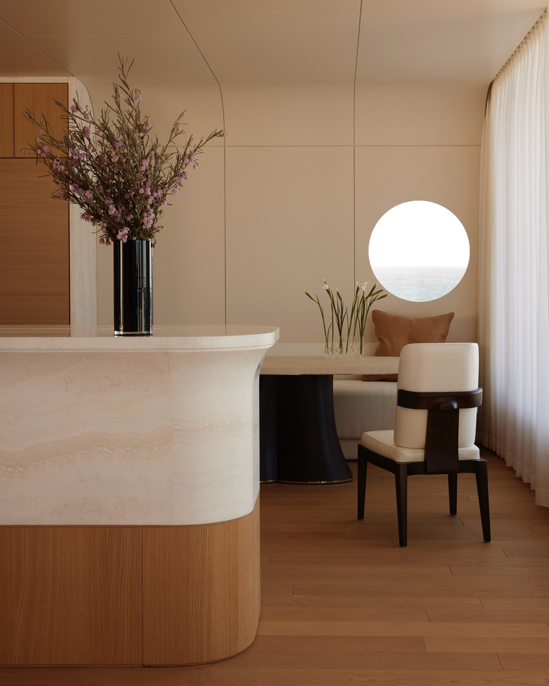 Press kit | 6087-07 - Press release | Study in Serenity: A Beachside Haven of Precision and Craftsmanship - Daniel Joseph Chenin - Residential Interior Design - <img alt="">The curved onyx island softens the geometry of the space, while a circular port window frames a precise view of the Pacific, echoing the home’s nautical inspiration and blending function with poetic detail.<img alt=""> - Photo credit: Tim Hirschmann
