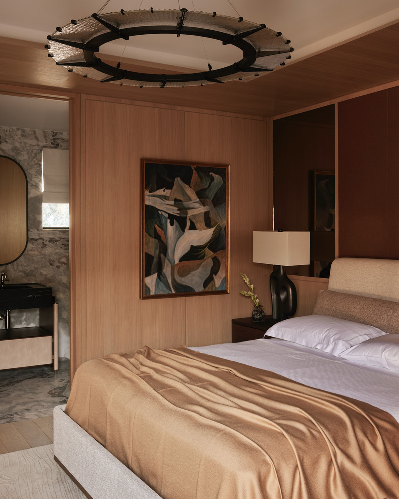 Press kit | 6087-07 - Press release | Study in Serenity: A Beachside Haven of Precision and Craftsmanship - Daniel Joseph Chenin - Residential Interior Design - In the guest suite, warm oak paneling and a tailored bed create an atmosphere of quiet comfort, while a sculptural light fixture overhead lends a contemporary accent to the intimate retreat. - Photo credit: Tim Hirschmann
