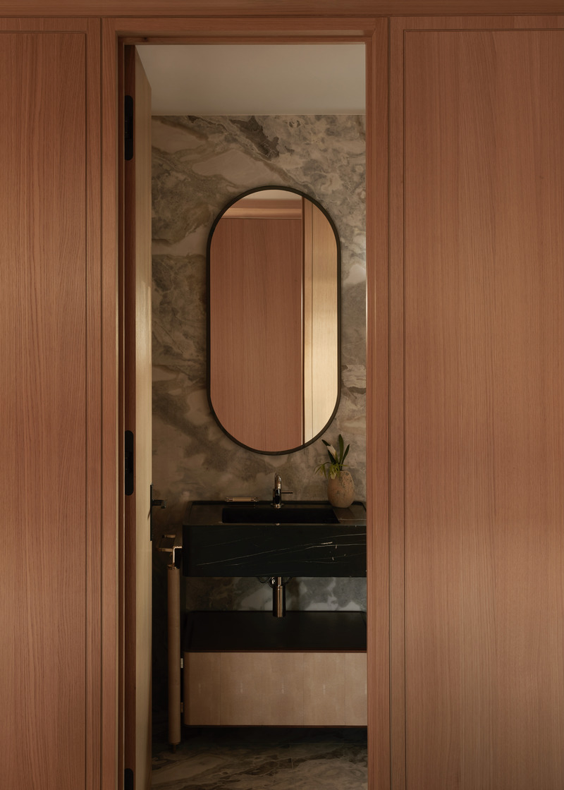 Press kit | 6087-07 - Press release | Study in Serenity: A Beachside Haven of Precision and Craftsmanship - Daniel Joseph Chenin - Residential Interior Design - A tailored guest suite vanity by Daniel Joseph Chenin, where honed stone, custom millwork, and an arched mirror converge in a restrained composition of elegance and quiet craft. - Photo credit: Tim Hirschmann