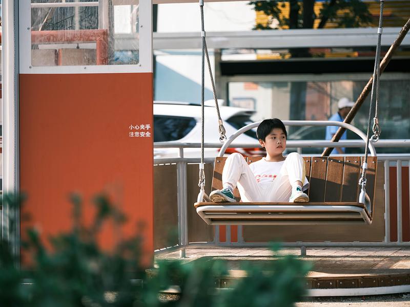 Press kit | 7020-04 - Press release | Old Beijing Bus: The Public Children's Space with a Bus Theme on the Streets of Changping - XISUI Design - Landscape Architecture - Child swinging in the early morning<br> - Photo credit:  Hu Yihao 