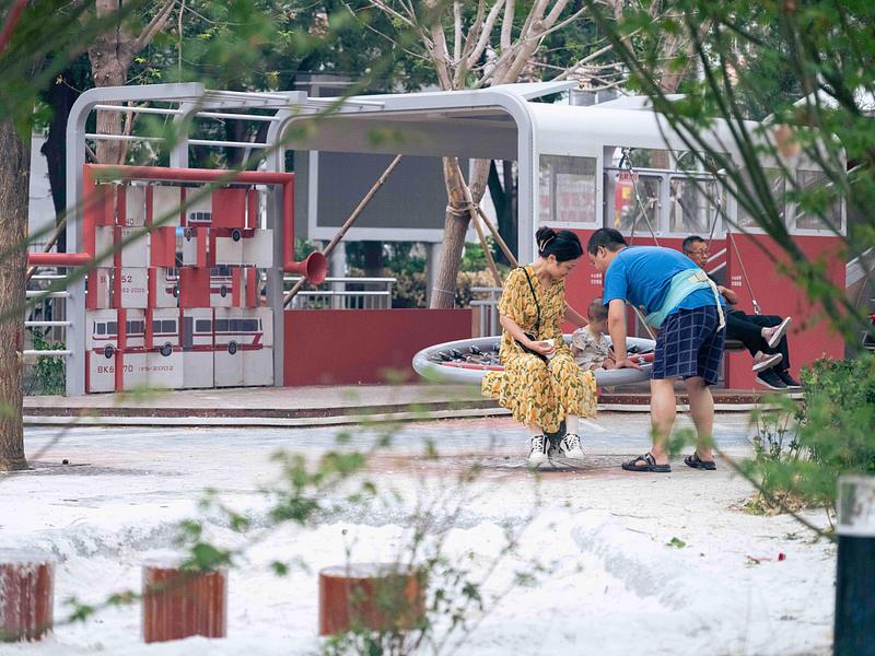 Press kit | 7020-04 - Press release | Old Beijing Bus: The Public Children's Space with a Bus Theme on the Streets of Changping - XISUI Design - Landscape Architecture - Local residents are playing with the turntable and swing in the rear area of the playground - Photo credit:  Hu Yihao 