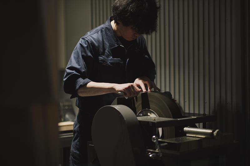 Dossier de presse | 7830-01 - Communiqué de presse | Tojiro Knife Gallery Osaka Wins Dezeen Award 2025 - KATATA YOSHIHITO DESIGN (L/O) - Design d’intérieur commercial - Maintenance room view with craftsman at work, integrated as part of the customer experience. - Crédit photo : Masaaki Inoue