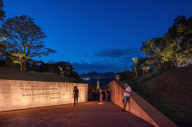 Dossier de presse | 7817-01 - Communiqué de presse | Memorial Brumadinho - Atiaîa Lighting Design - Design d’éclairage - <p class="">“What memory loves remains eternal. I love you with memory, imperishable.” Adélia Prado's poem plan grazing lights presents the low relief of signage letters with light and shadow effects, also highlighting texture and color of the concrete mixed with pigment of the mining waste.</p> - Crédit photo : Pedro Mascaro