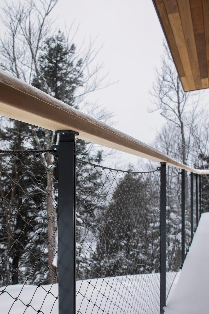 Press kit | 2054-05 - Press release | Laurentian Forest House - RobitailleCurtis - Residential Architecture - A detail of the custom guardrail designed for transparency using stainless steel mesh from Carl Stahl. - Photo credit: Adrien Williams