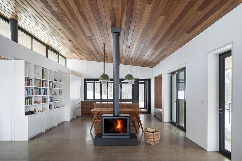 Press kit | 2054-05 - Press release | Laurentian Forest House - RobitailleCurtis - Residential Architecture -  A view in the living bar look east from the living room towards the dining and kitchen areas.  The clerestory windows have operable units for passive cooling in summer  - Photo credit: Adrien Williams
