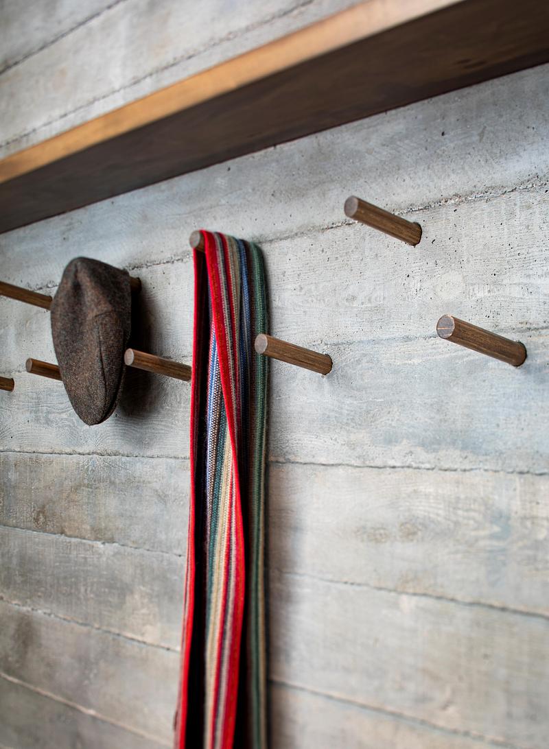 Press kit | 2054-05 - Press release | Laurentian Forest House - RobitailleCurtis - Residential Architecture - Coat pegs in the board formed concrete wall at the entry vestibule.  - Photo credit: Adrien Williams