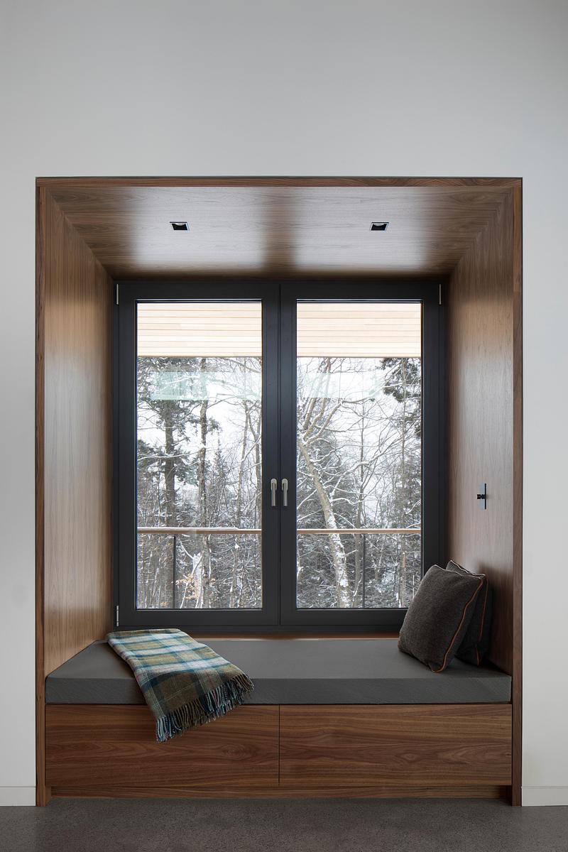 Press kit | 2054-05 - Press release | Laurentian Forest House - RobitailleCurtis - Residential Architecture - A detail photo of one of the two walnut lined reading nooks in the living bar. - Photo credit: Adrien Williams