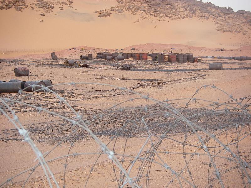 Press kit | 748-54 - Press release | UQAM’s Centre de design Presents "Toxicité coloniale : Architecture et paysage radioactifs français dans le Sahara" - Centre de design de l'UQAM - Event + Exhibition - <p style="">Abandoned barrels in the Sahara around the former Reggane Saharan Military Testing Centre, 2007, </p> - Photo credit:  Bruno Barrillot. With kind permission of the Armaments Observatory (https://www.obsarm.info/). 