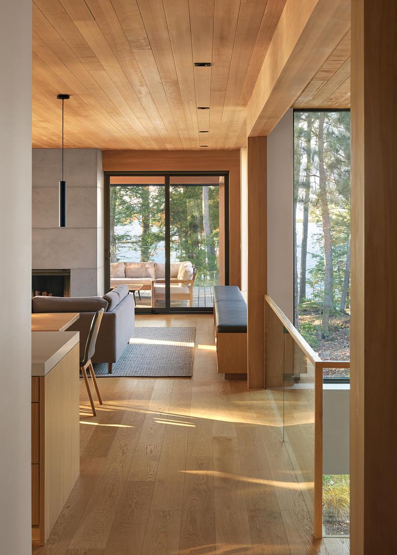 Press kit | 1513-21 - Press release | Long Lake Cottage - Dubbeldam Architecture + Design - Residential Architecture - <p class="">The upper-level living spaces float above the forest, with wrap-around windows and sliding doors opening to a sunlit deck that blurs the line between indoors and out.</p> - Photo credit:  Riley Snelling 