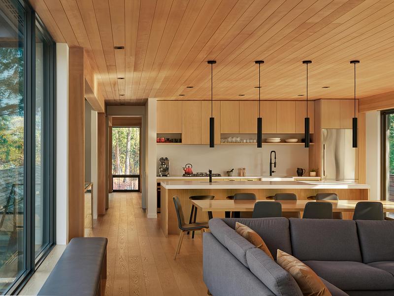 Press kit | 1513-21 - Press release | Long Lake Cottage - Dubbeldam Architecture + Design - Residential Architecture - The open plan living, dining room, and kitchen<br>merge seamlessly, fostering connection within<br>the space. Every circulation route terminates<br>at a window or door, ensuring constant visual<br>access to the surrounding landscape.<br> - Photo credit:  Riley Snelling 