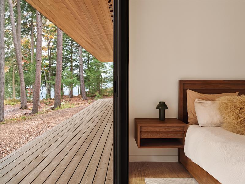 Press kit | 1513-21 - Press release | Long Lake Cottage - Dubbeldam Architecture + Design - Residential Architecture -  The lower-level bedrooms open to the<br>forest through floor-to-ceiling windows<br>and dedicated exterior entrances, offering guests a direct connection to the<br>landscape.<br>  - Photo credit:  Riley Snelling 