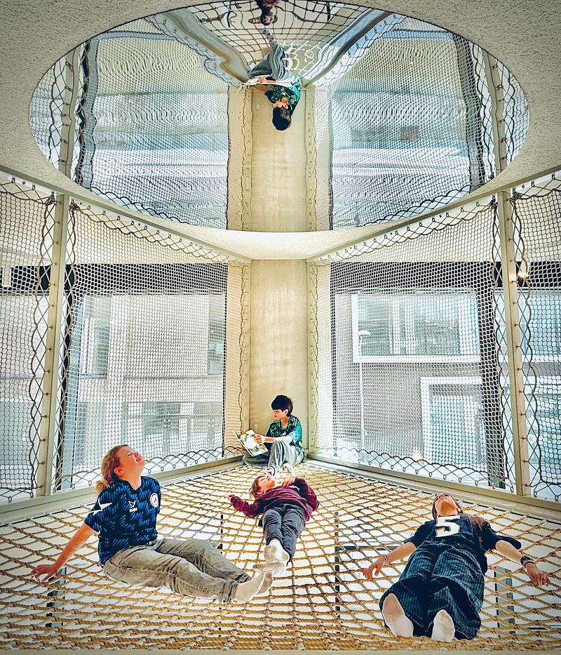 Dossier de presse | 7860-01 - Communiqué de presse | KiMu Children's Art Museum Opens in Amsterdam - KiMu Kinderkunstmuseum - Art -  A suspended net stretched across the central space offers a place to relax and unwind, while offering views into the main hall. A mirror above reflecting light and the water outside back into the interior. Design: WE architecten, built by OneTwoTree  - Crédit photo :  Morad Bouchakour