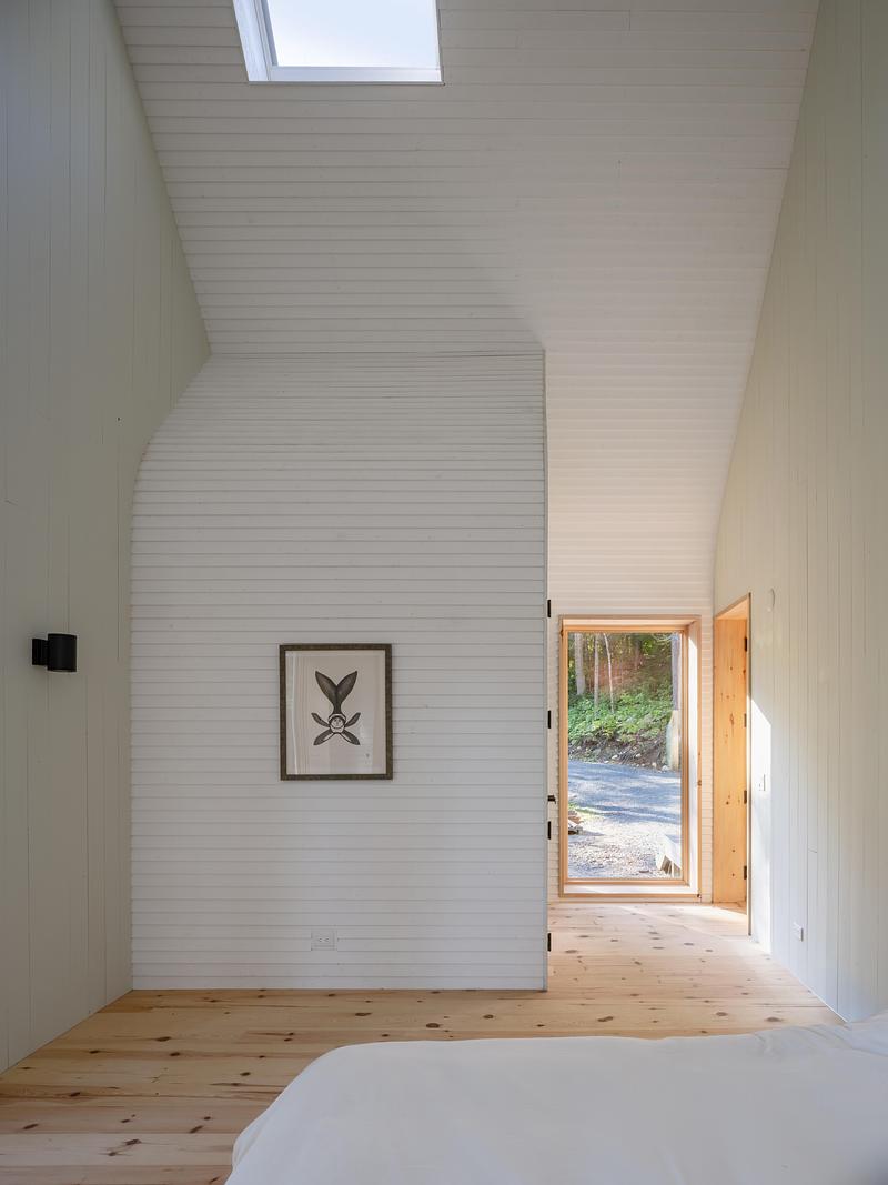 Press kit | 2682-03 - Press release | DogTrot Magnetawan - Williamson Williamson inc - Residential Architecture - The primary bedroom gable walls are painted pale green. The small volume inset into the space is a small bathroom that is closed down for winter.  - Photo credit: Scott Norsworthy