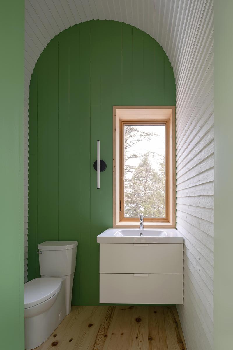 Press kit | 2682-03 - Press release | DogTrot Magnetawan - Williamson Williamson inc - Residential Architecture - The Primary Bathroom is a small two-piece bathroom that can be closed for the winter when the owners move into the main house and use the woodburning stove as the primary source of heat. - Photo credit: Scott Norsworthy
