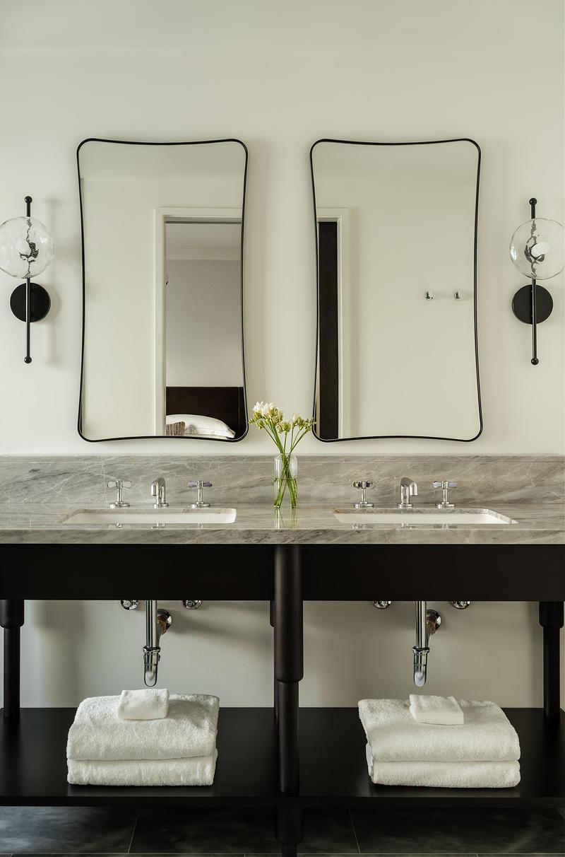 Dossier de presse | 2757-64 - Communiqué de presse | Narrative Design Studio’s Design for the Kimpton Mirador Pacific Grove Unites Sophistication and Simplicity - Narrative Design Studio - Design d’intérieur commercial - The bathroom's double vanity pairs elegant stone surfaces with sculptural mirrors and refined fixtures.  - Crédit photo : Elizabeth Nielson