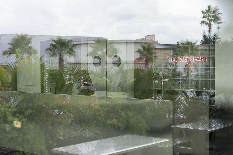 Dossier de presse | 4232-24 - Communiqué de presse | Un diner contemporain comme système spatial - Didea - Architecture commerciale -  Le passe-plat, encadré de pavés de verre et d'une enseigne lumineuse rouge, transforme un seuil fonctionnel en véritable point focal de l'architecture  - Crédit photo : Paolo Riolzi