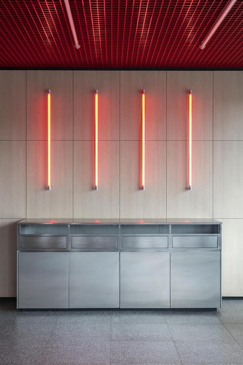 Dossier de presse | 4232-24 - Communiqué de presse | Un diner contemporain comme système spatial - Didea - Architecture commerciale - Quatre éléments lumineux verticaux rouges ponctuent le mur et introduisent un rythme discret dans l'espace  - Crédit photo : Paolo Riolzi