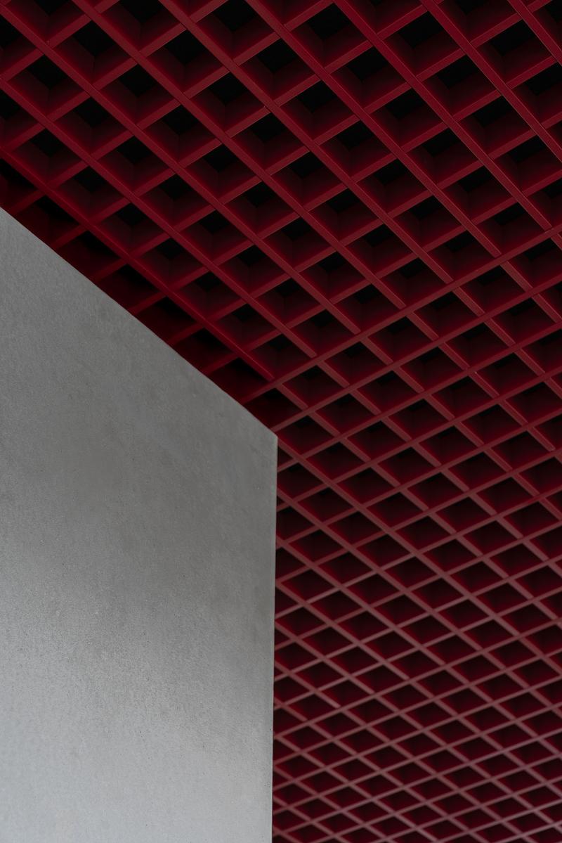 Dossier de presse | 4232-24 - Communiqué de presse | Un diner contemporain comme système spatial - Didea - Architecture commerciale - La grille métallique rouge du plafond constitue le geste architectural le plus identifiable du projet, donnant à l'espace son échelle et son identité - Crédit photo : Paolo Riolzi