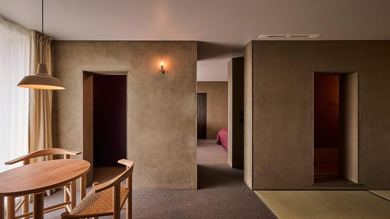 Press kit | 7919-01 - Press release | Né Wins Architecture + Environment by Public Vote at the Architizer A+Awards 2026 - Ahead of the Curve Inc. - Commercial Architecture - Interior earthen walls along a passage leading to a guest room. - Photo credit: Hiroki Kawata
