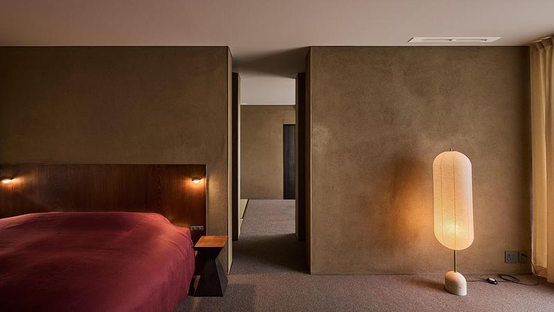 Press kit | 7919-01 - Press release | Né Wins Architecture + Environment by Public Vote at the Architizer A+Awards 2026 - Ahead of the Curve Inc. - Commercial Architecture - A guest room finished in earthen walls, with a floor lamp. - Photo credit: Hiroki Kawata