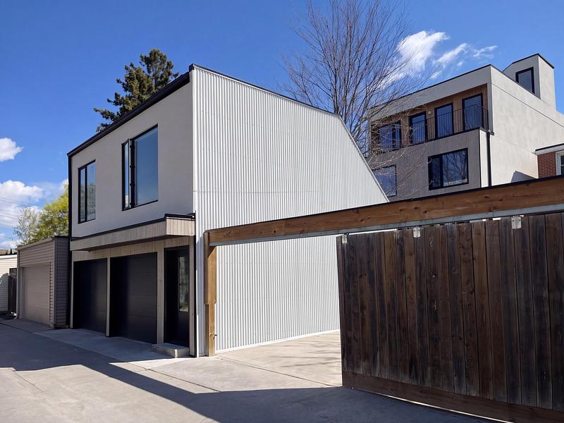 Dossier de presse | 2344-04 - Communiqué de presse | Three Homes on One Toronto Lot Create Room to Stay - baukultur/ca - Architecture résidentielle - Rear view of the laneway home with a sloping metal-clad roof and multiplex building with the other 2 homes to the right.  - Crédit photo : baukultur/ca