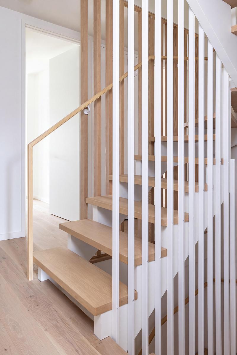 Dossier de presse | 2344-04 - Communiqué de presse | Three Homes on One Toronto Lot Create Room to Stay - baukultur/ca - Architecture résidentielle - Unit A oak staircase framed by slender white metal balusters and sculptural timber handrail. - Crédit photo : Jack Gifford Photography