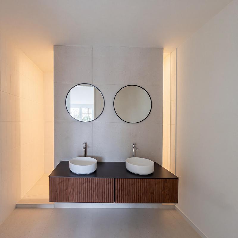 Dossier de presse | 2344-04 - Communiqué de presse | Three Homes on One Toronto Lot Create Room to Stay - baukultur/ca - Architecture résidentielle - Unit B bathroom with twin basins, round mirrors and a floating timber vanity.The shower is hidden behind the free standing wall.   - Crédit photo : baukultur/ca