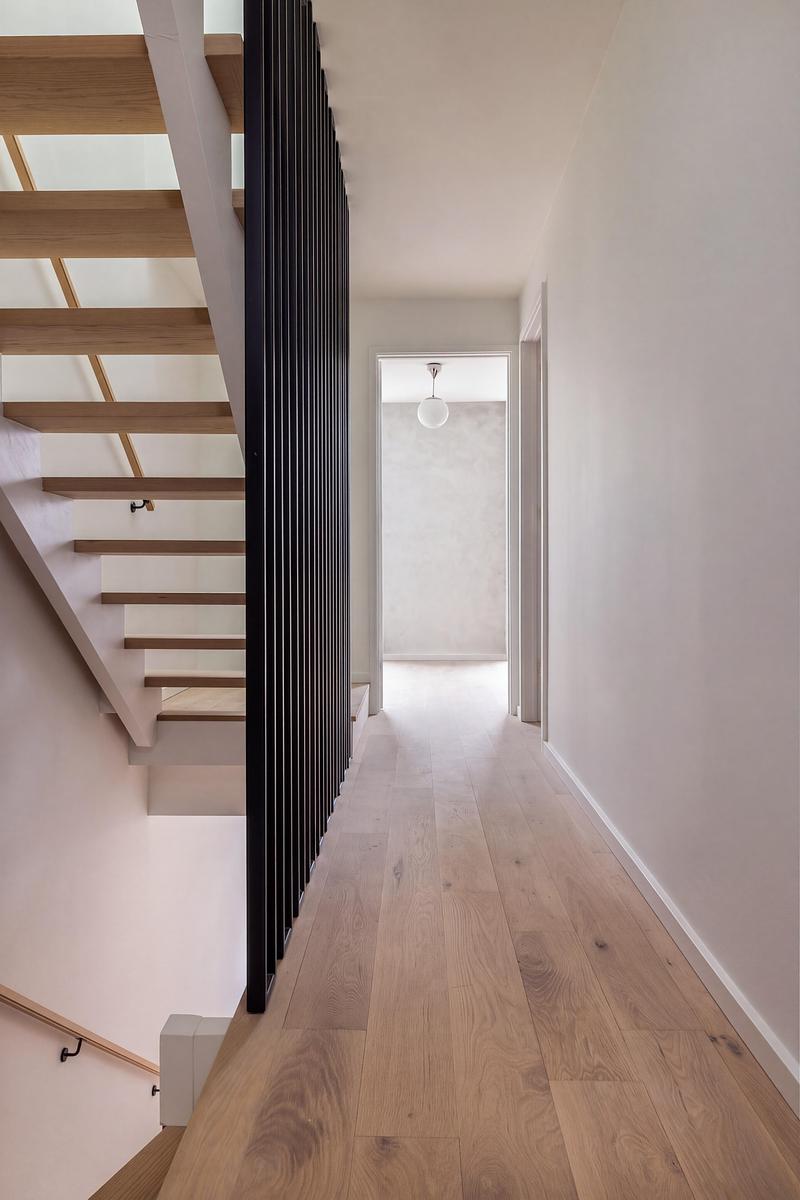 Dossier de presse | 2344-04 - Communiqué de presse | Three Homes on One Toronto Lot Create Room to Stay - baukultur/ca - Architecture résidentielle - Unit B hallway alongside an open timber staircase and black vertical metal balustrade. - Crédit photo : Jack Gifford Photography